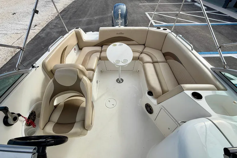 Slide: The Image of 2014 NauticStar 223DC Sport Deck boat interior with beige seating and round table. - 14