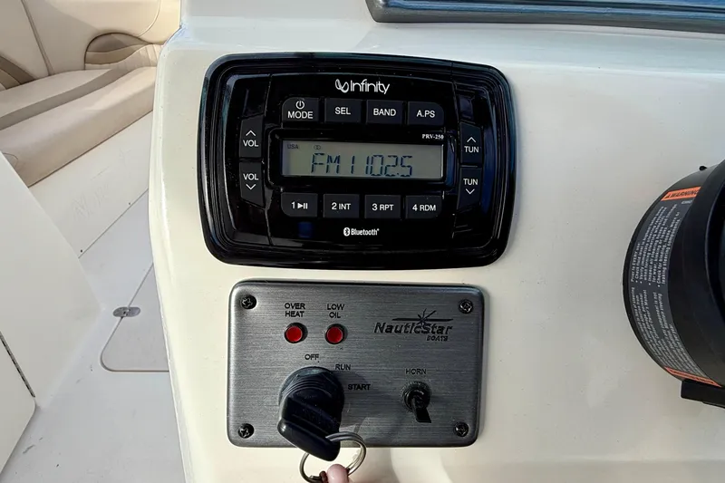 Slide: The Image of Control panel of 2014 NauticStar 223DC Sport Deck with radio and ignition key. - 18