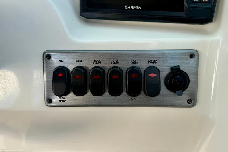 Slide: The Image of Control panel of a 2014 NauticStar 223DC Sport Deck boat with labeled switches. - 19