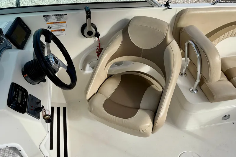 Slide: The Image of 2014 NauticStar 223DC Sport Deck boat interior with steering wheel and beige seating. - 21