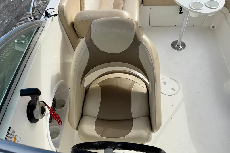 Slide: The Image of 2014 NauticStar 223DC Sport Deck boat interior with beige seating and steering wheel. - 22