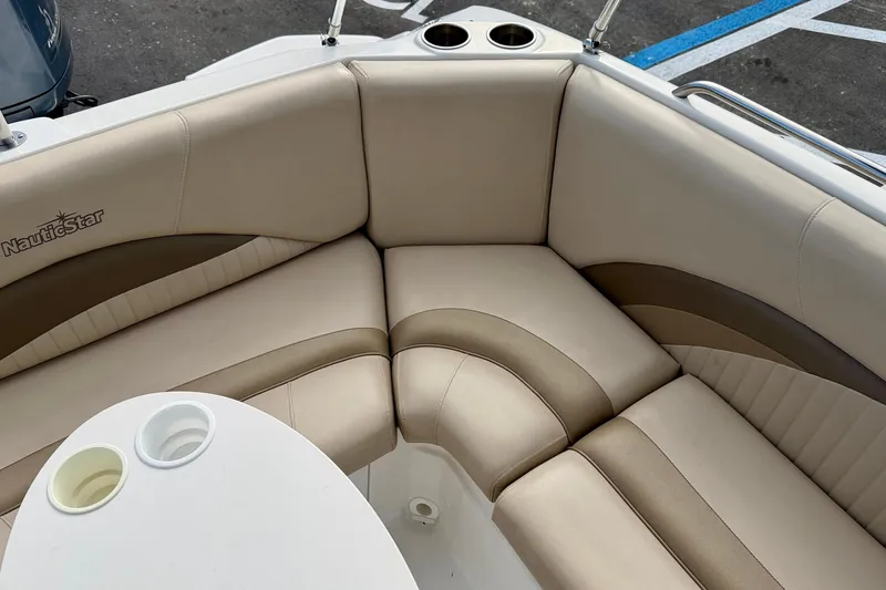 Slide: The Image of 2014 NauticStar 223DC Sport Deck boat interior with beige seating and cup holders. - 25