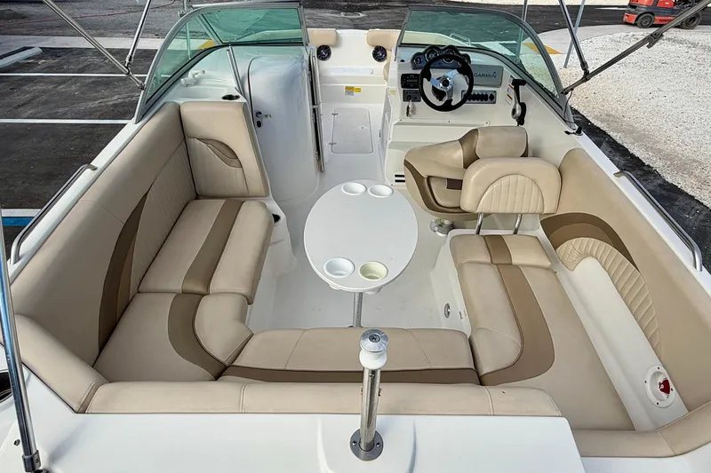 Slide: The Image of 2014 NauticStar 223DC Sport Deck interior with beige seating and steering console. - 28