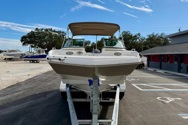 Slide: The Image of 2014 NauticStar 223DC Sport Deck boat on trailer, parked in a marina lot. - 3