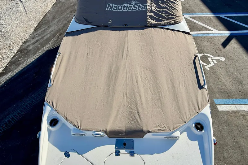 Slide: The Image of 2014 NauticStar 223DC Sport Deck boat with protective cover in parking lot. - 30