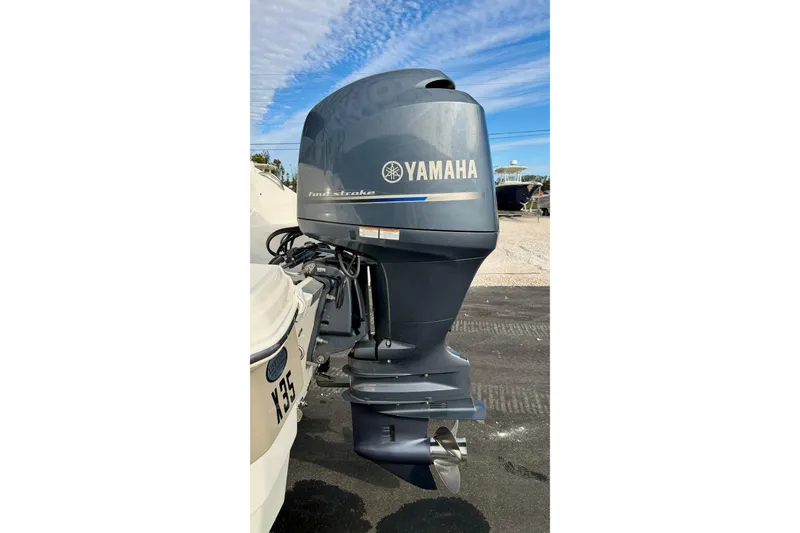 Slide: The Image of 2014 NauticStar 223DC Sport Deck with Yamaha outboard motor, parked outdoors. - 32