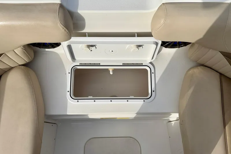 Slide: The Image of 2014 NauticStar 223DC Sport Deck interior with open storage compartment and beige seating. - 36