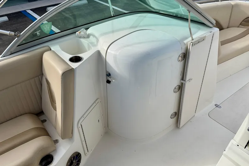Slide: The Image of 2014 NauticStar 223DC Sport Deck interior with beige seating and storage compartment. - 39