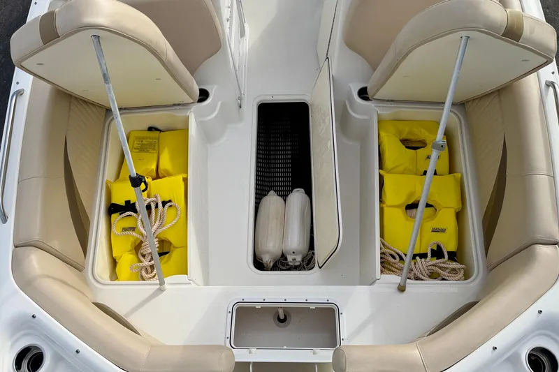 Slide: The Image of 2014 NauticStar 223DC Sport Deck boat interior with storage compartments and safety gear. - 42