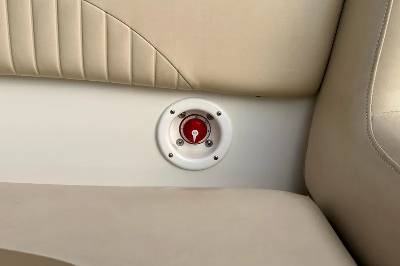 Slide: The Image of 2014 NauticStar 223DC Sport Deck interior with red switch on beige upholstery. - 43