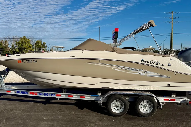 Slide: The Image of 2014 NauticStar 223DC Sport Deck boat on trailer under clear sky. - 45