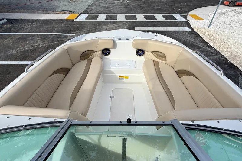 Slide: The Image of 2014 NauticStar 223DC Sport Deck boat with beige seating and spacious deck layout. - 9