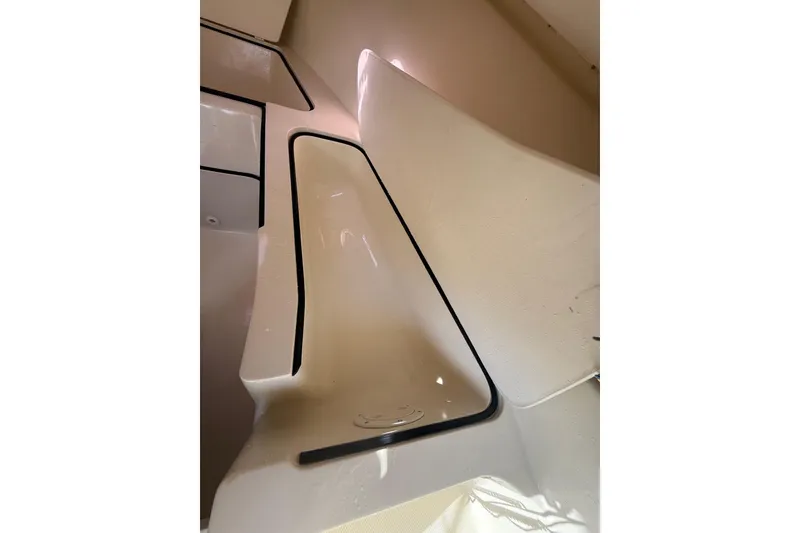 Slide: The Image of Interior view of a 2004 Holby Pilot 19 boat, featuring sleek white surfaces. - 12