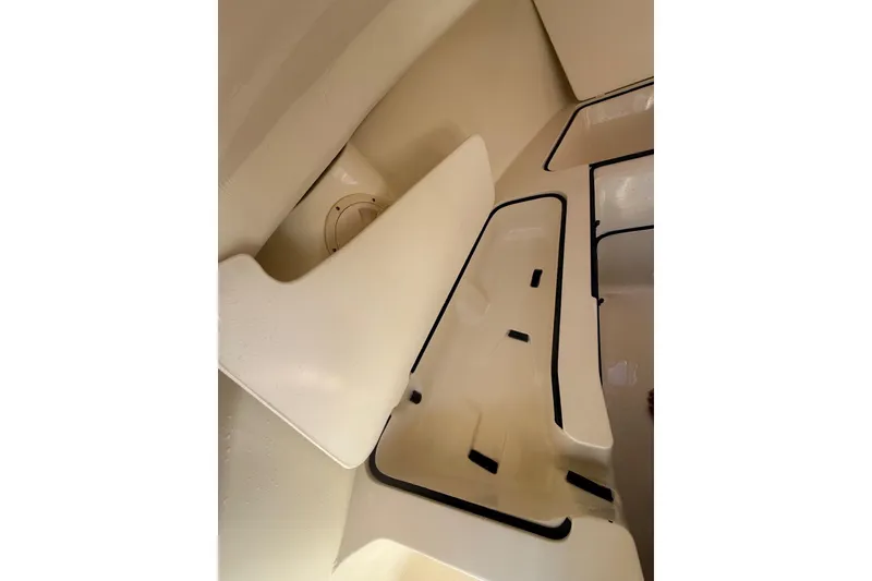 Slide: The Image of Interior view of a 2004 Holby Pilot 19 boat, showcasing seating and storage areas. - 13
