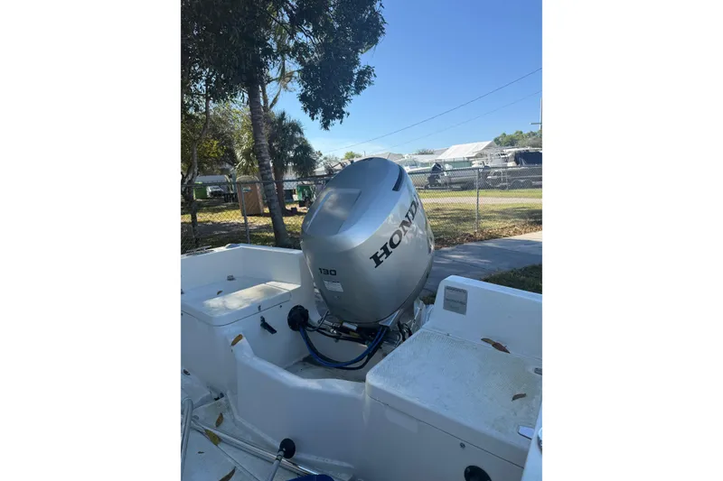 Slide: The Image of Holby Pilot 19 boat, 2004 model, docked near palm trees and vehicles. - 2