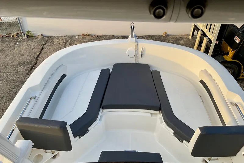 Slide: The Image of 2021 Bayliner Trophy T20CC boat interior with cushioned seating and storage. - 11