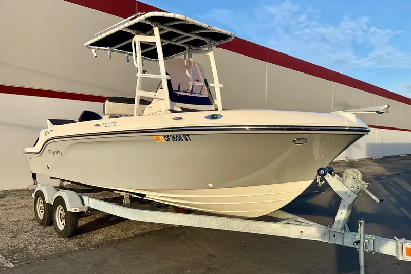 Slide: The Image of 2021 Bayliner Trophy T20CC boat on trailer, parked outdoors. - 16