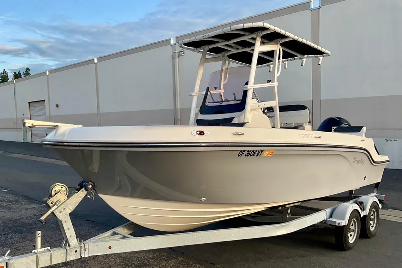 Slide: The Image of 2021 Bayliner Trophy T20CC boat on trailer, parked outdoors. - 2