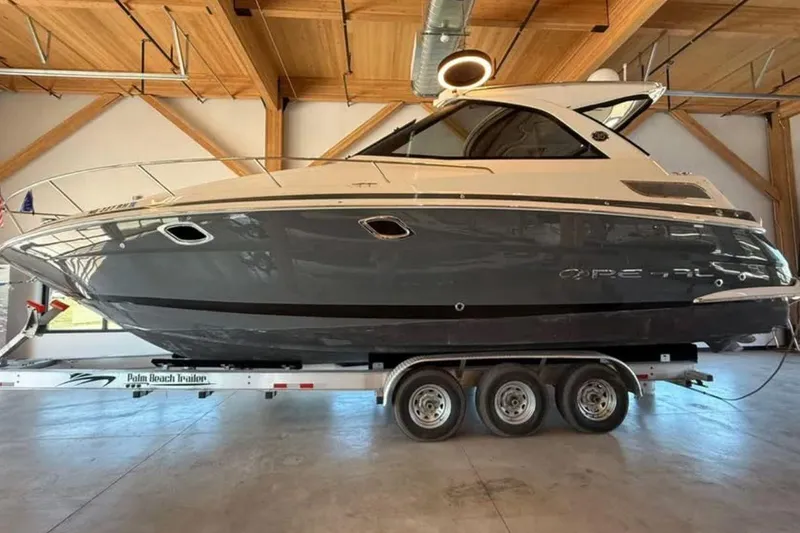 The Image of 2019 Regal 35 Sport Coupe boat on trailer in wooden garage. - 0