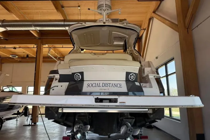 Slide: The Image of 2019 Regal 35 Sport Coupe boat named "Social Distance" in a wooden interior setting. - 18