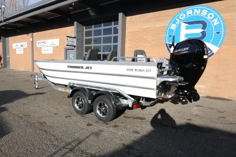 Slide: The Image of 2026 Thunder Jet 209 Rush OT boat on trailer, parked outside dealership. - 7