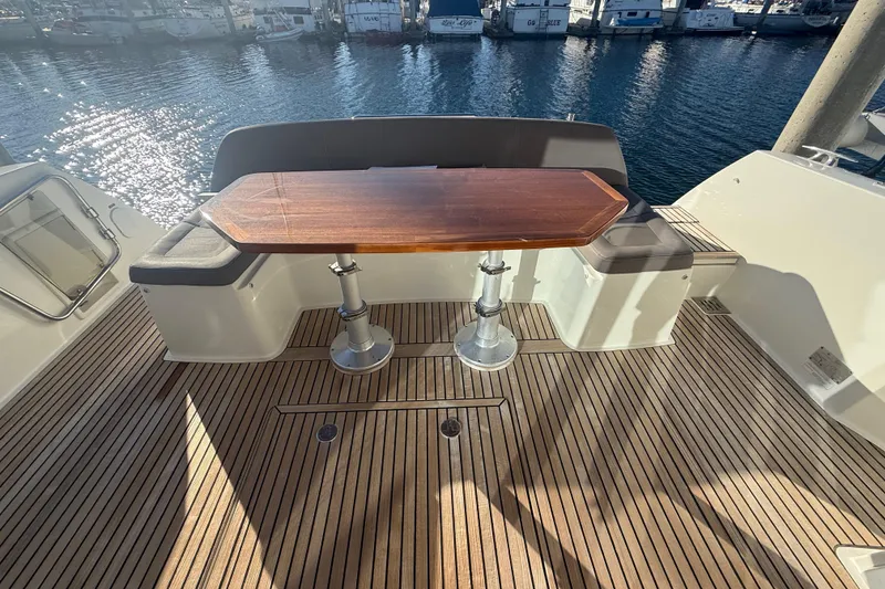Slide: The Image of Prestige 450S 2016 yacht deck with wooden table and cushioned seating. - 10