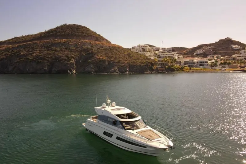 Slide: The Image of 2016 Prestige 450S yacht cruising near scenic coastal hills and luxury homes. - 4