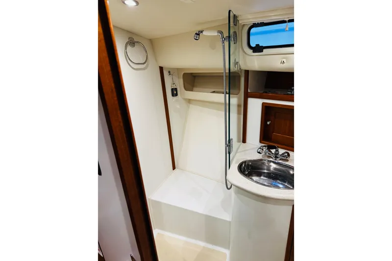 Slide: The Image of 2015 MJM 36z Express yacht bathroom with shower, sink, and wooden cabinetry. - 21