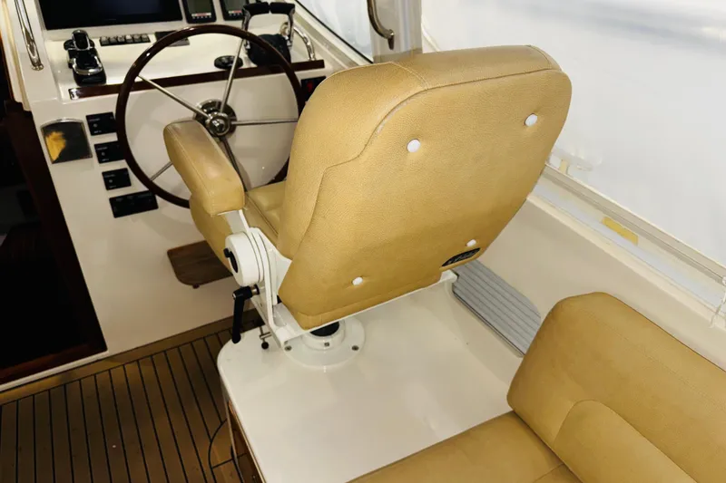 Slide: The Image of Captain's chair and helm of 2015 MJM 36z Express boat, featuring tan upholstery. - 33