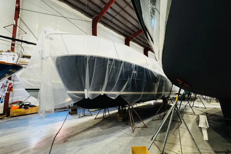 Slide: The Image of 2015 MJM 36z Express yacht covered in plastic, stored indoors. - 48