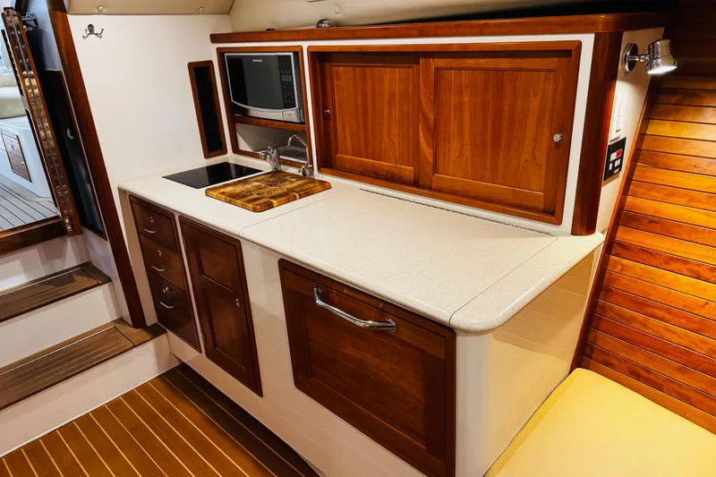 Slide: The Image of 2015 MJM 36z Express yacht interior with wooden cabinetry and modern kitchenette. - 8