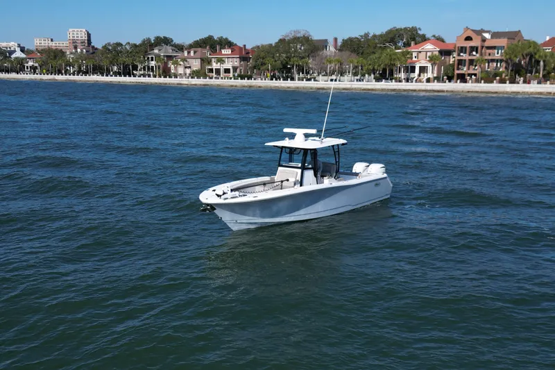 Slide: The Image of 2025 Sea Hunt Gamefish 30 Coffin Box boat on water near coastal homes. - 3