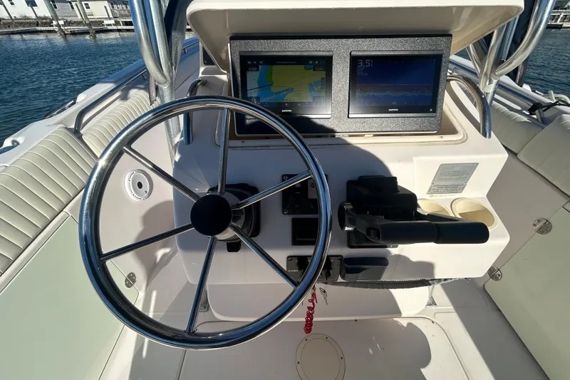Slide: The Image of 2003 Grady-White Chase 273 boat helm with steering wheel and navigation screens. - 17