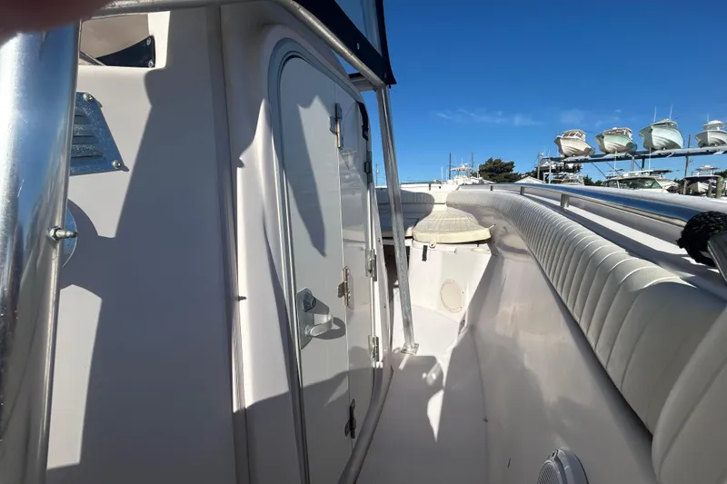 Slide: The Image of 2003 Grady-White Chase 273 boat interior with white seating and storage compartments. - 28