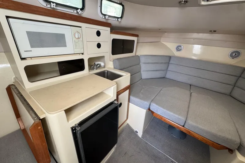 Slide: The Image of 2001 Albin 28 Tournament Express interior with kitchenette and cushioned seating area. - 10