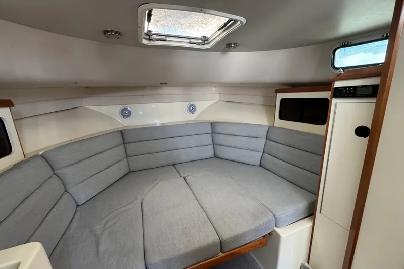 Slide: The Image of 2001 Albin 28 Tournament Express cabin interior with gray seating and wood accents. - 12