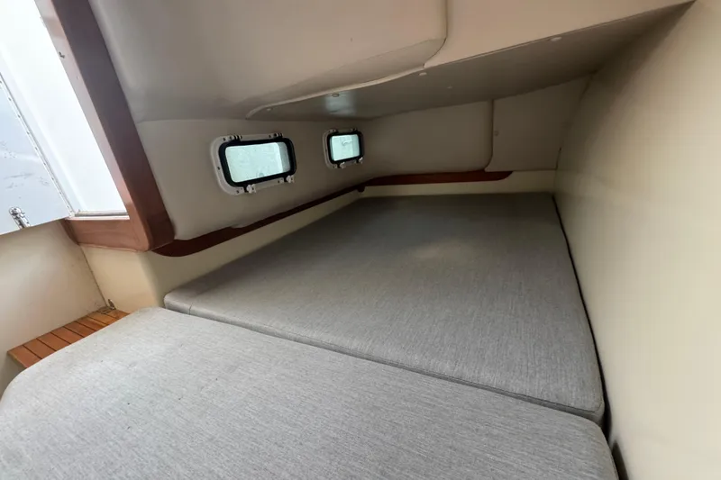 Slide: The Image of 2001 Albin 28 Tournament Express cabin interior with cushioned sleeping area and porthole windows. - 15