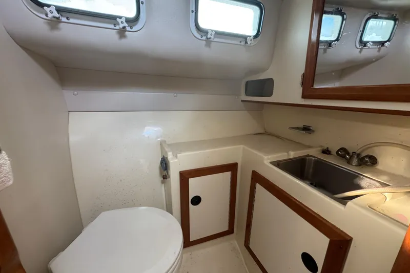 Slide: The Image of 2001 Albin 28 Tournament Express boat bathroom with sink, toilet, and storage cabinets. - 16