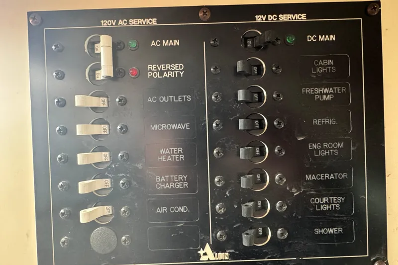Slide: The Image of Electrical panel of a 2001 Albin 28 Tournament Express boat, showing AC and DC service switches. - 19