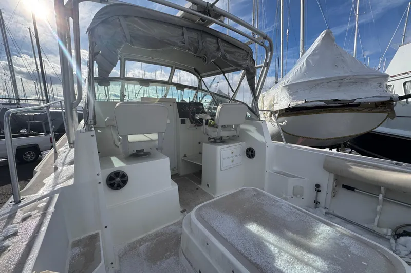 Slide: The Image of 2001 Albin 28 Tournament Express boat interior with helm, seats, and marina background. - 3