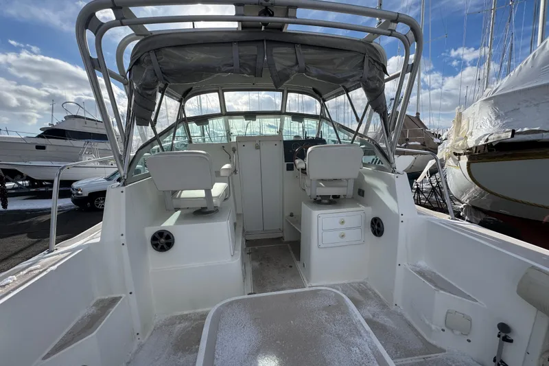 Slide: The Image of 2001 Albin 28 Tournament Express boat interior with helm and seating, docked under cloudy sky. - 4