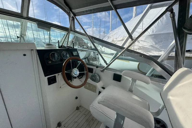 Slide: The Image of 2001 Albin 28 Tournament Express helm with steering wheel and gauges, docked under clear sky. - 6