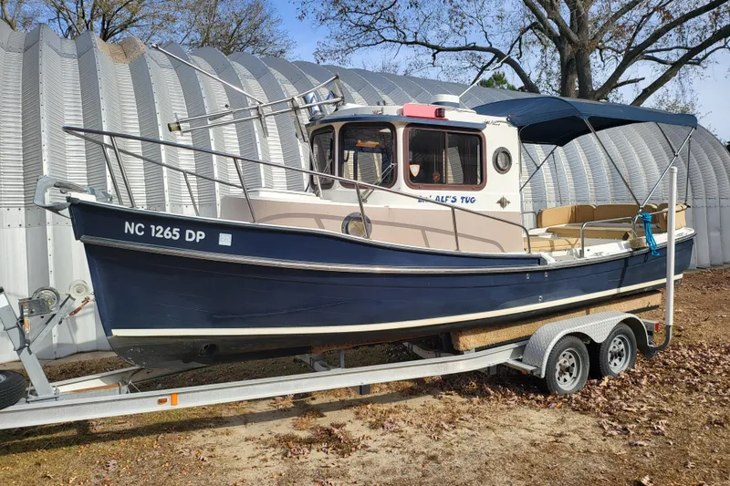Slide: The Image of 2009 Ranger Tugs R-21 EC boat on trailer, parked outdoors near metal building. - 9