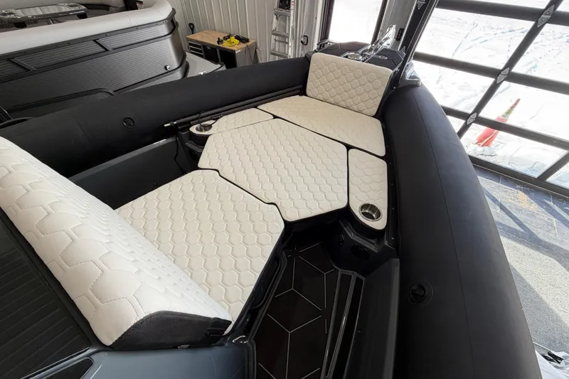 Slide: The Image of 2026 Highfield ADV 7 boat interior with hexagonal-patterned white seating and cup holders. - 13