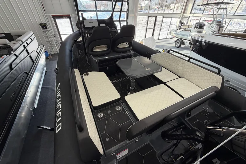 Slide: The Image of 2026 Highfield ADV 7 boat interior with seating and table in showroom. - 4