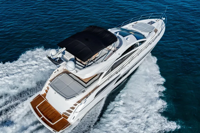 Slide: The Image of 2014 Sunseeker 68 Sport Yacht cruising on open water, aerial view. - 4
