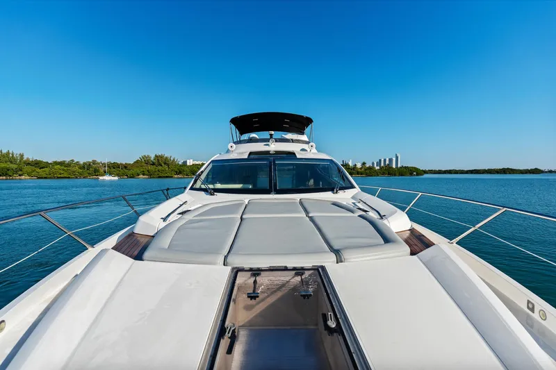 Slide: The Image of Sunseeker 68 Sport Yacht 2014 on serene blue waters, featuring spacious sunbathing area. - 51