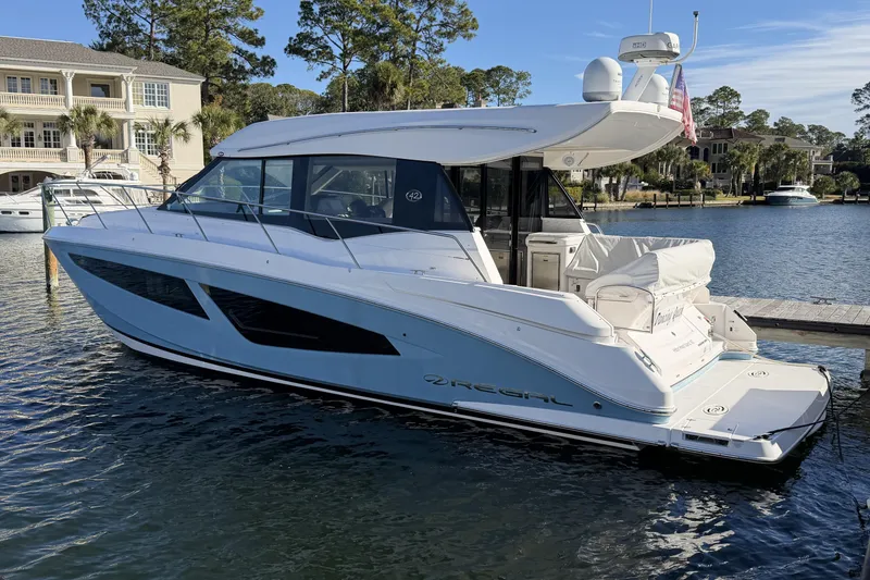 The Image of 2019 Regal 42 Grande Coupe yacht docked in a scenic marina setting. - 0