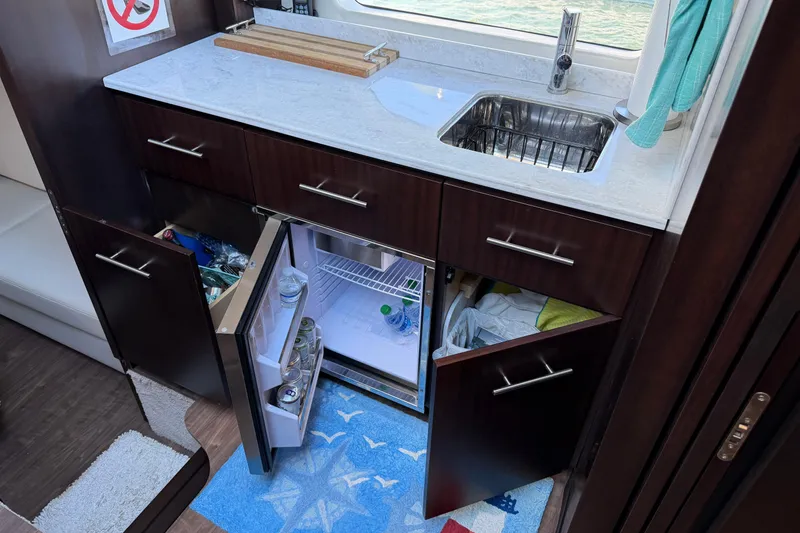 Slide: The Image of Interior of 2019 Regal 42 Grande Coupe yacht kitchen with sink and open fridge. - 36