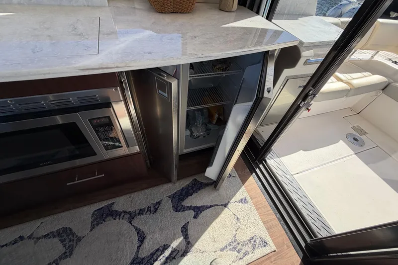 Slide: The Image of 2019 Regal 42 Grande Coupe yacht interior with open fridge and microwave. - 46